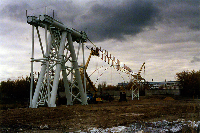 Под руководством генерального конструктора и автора СТЮ Анатолия Юницкого на испытательном полигоне осуществляется монтаж рельсо-струнной путевой структуры на строящемся стенде СТЮ Путевая структура