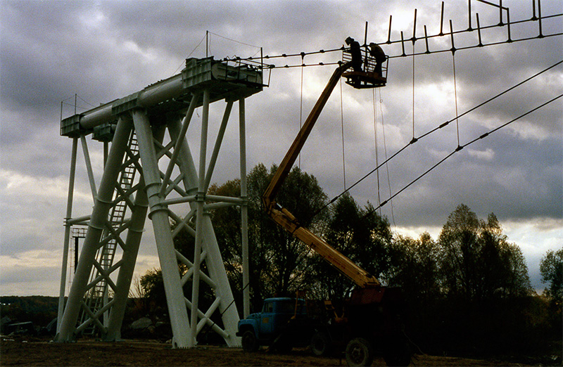 Под руководством генерального конструктора и автора СТЮ Анатолия Юницкого на испытательном полигоне осуществляется монтаж рельсо-струнной путевой структуры на строящемся стенде СТЮ Путевая структура