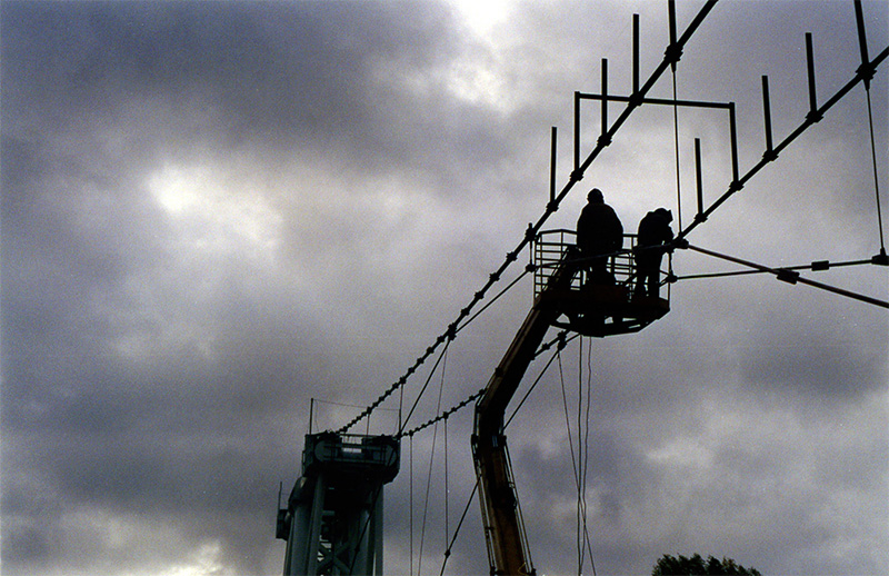 Под руководством генерального конструктора и автора СТЮ Анатолия Юницкого на испытательном полигоне осуществляется монтаж рельсо-струнной путевой структуры на строящемся стенде СТЮ Путевая структура