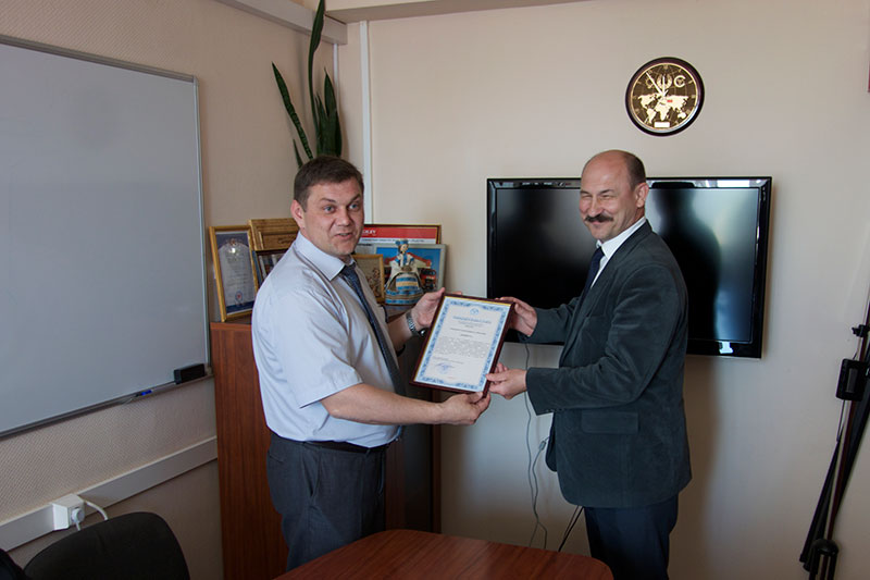 Глава администрации СЭЗ Могилев Андрей Ярцев вручает директору ЗАО Юнибус Евгению Пахолкову свидетельство, подтверждающее резидентство в СЭЗ Могилев