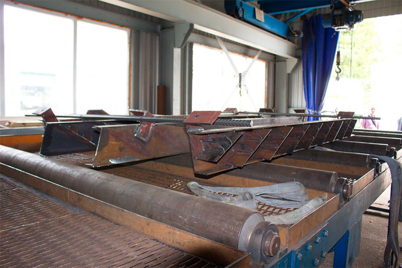 Загрузка в дробемётную камеру заготовок лестничных маршей анкерной опоры городской и высокоскоростной трассы SkyWay