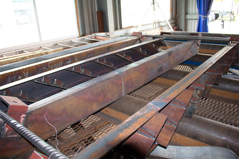 Загрузка в дробемётную камеру заготовок лестничных маршей анкерной опоры городской и высокоскоростной трассы SkyWay